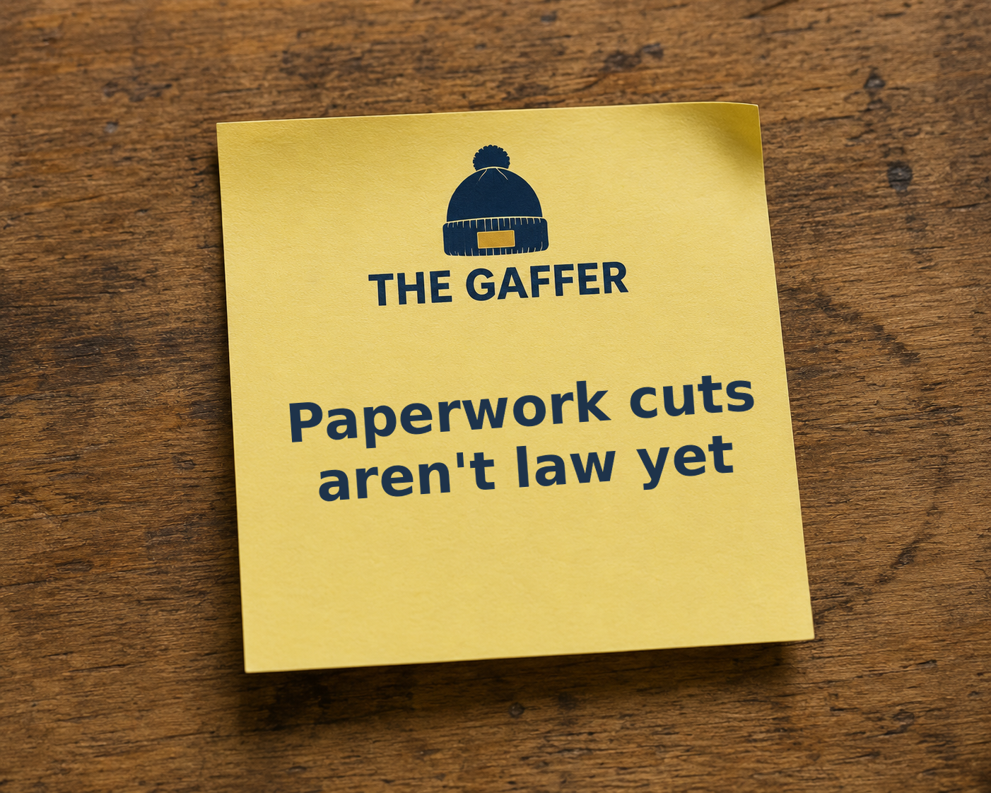 Yellow Post-it note on a wooden desk, headed with The Gaffer bobble-hat logo, reading: Paperwork cuts aren't law yet.